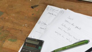 workplace with calculator and paper sheets with pens